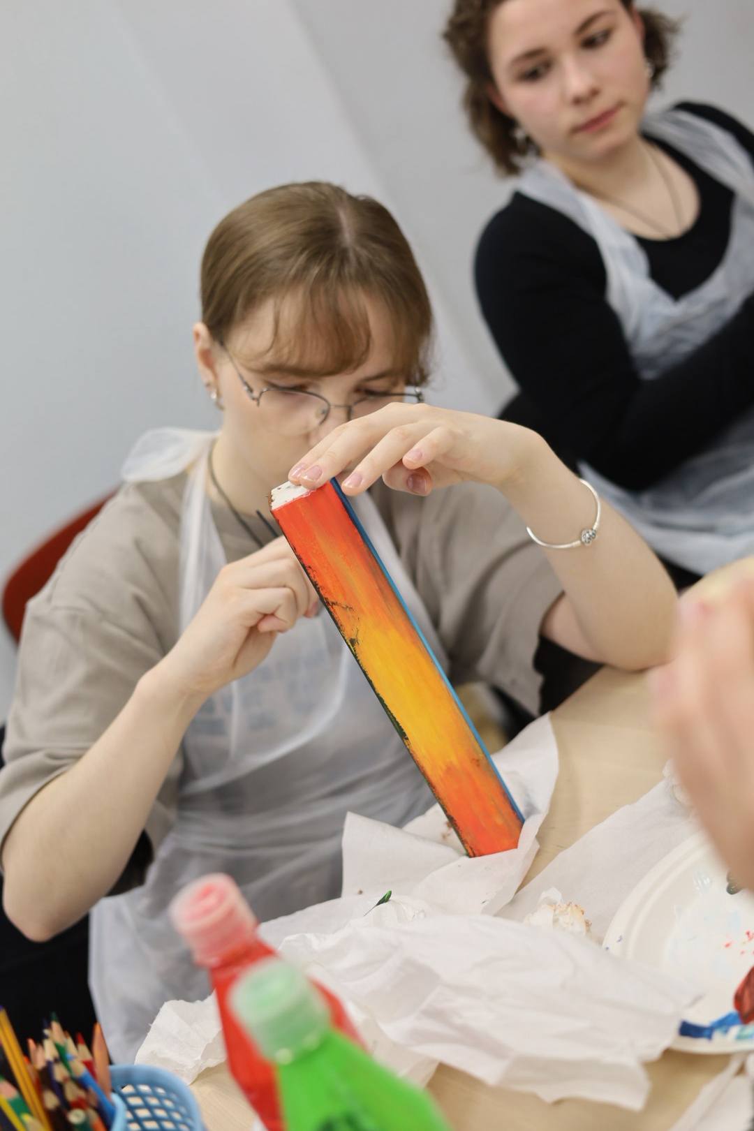 Dalyvė kruopščiai dekoruoja kūrinį
